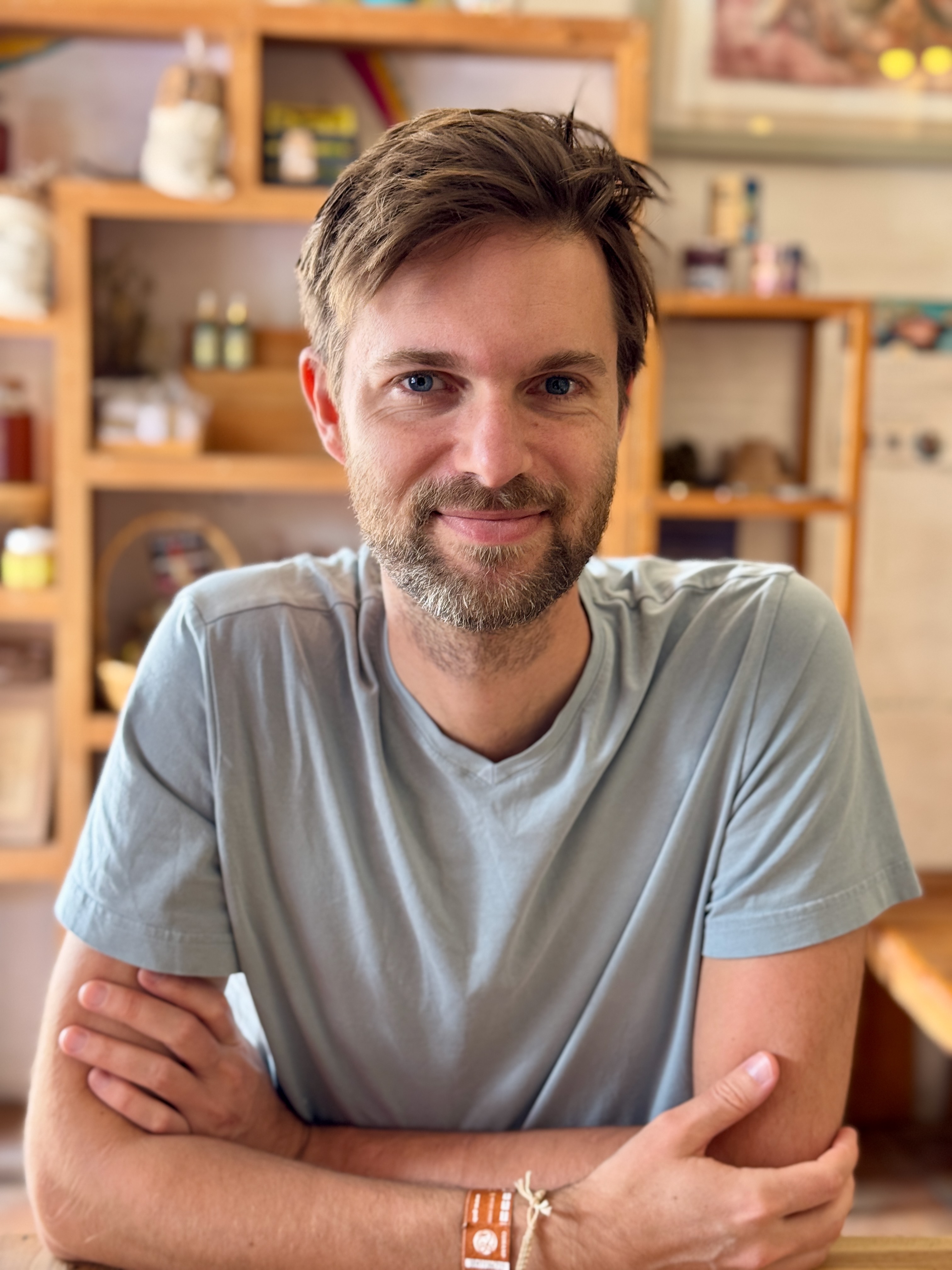 Jesko, smiling with arms folded in a warm sunlit room